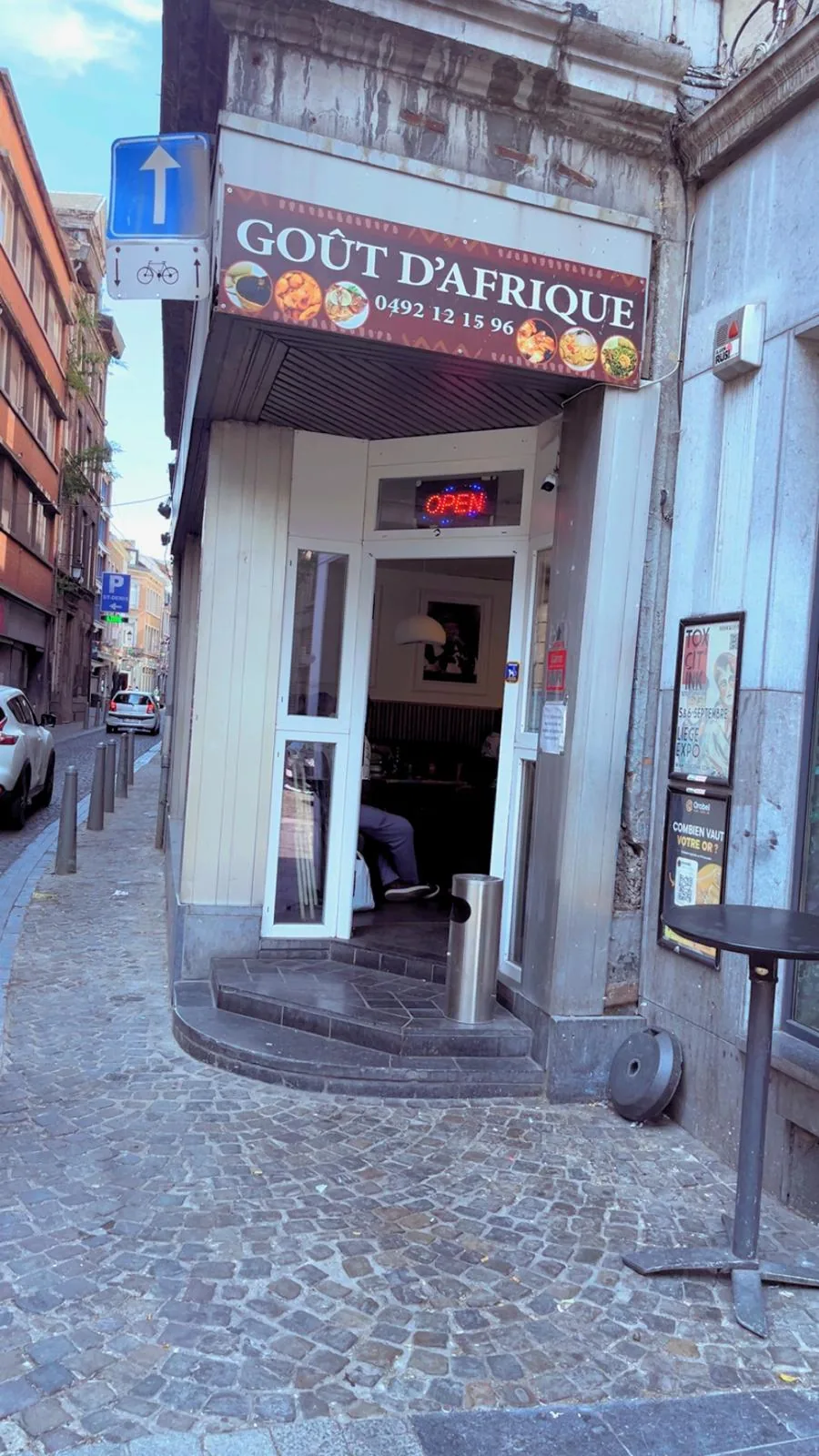 Entrée du restaurant Goût d’Afrique et son enseigne, dans une rue pavée de Liège