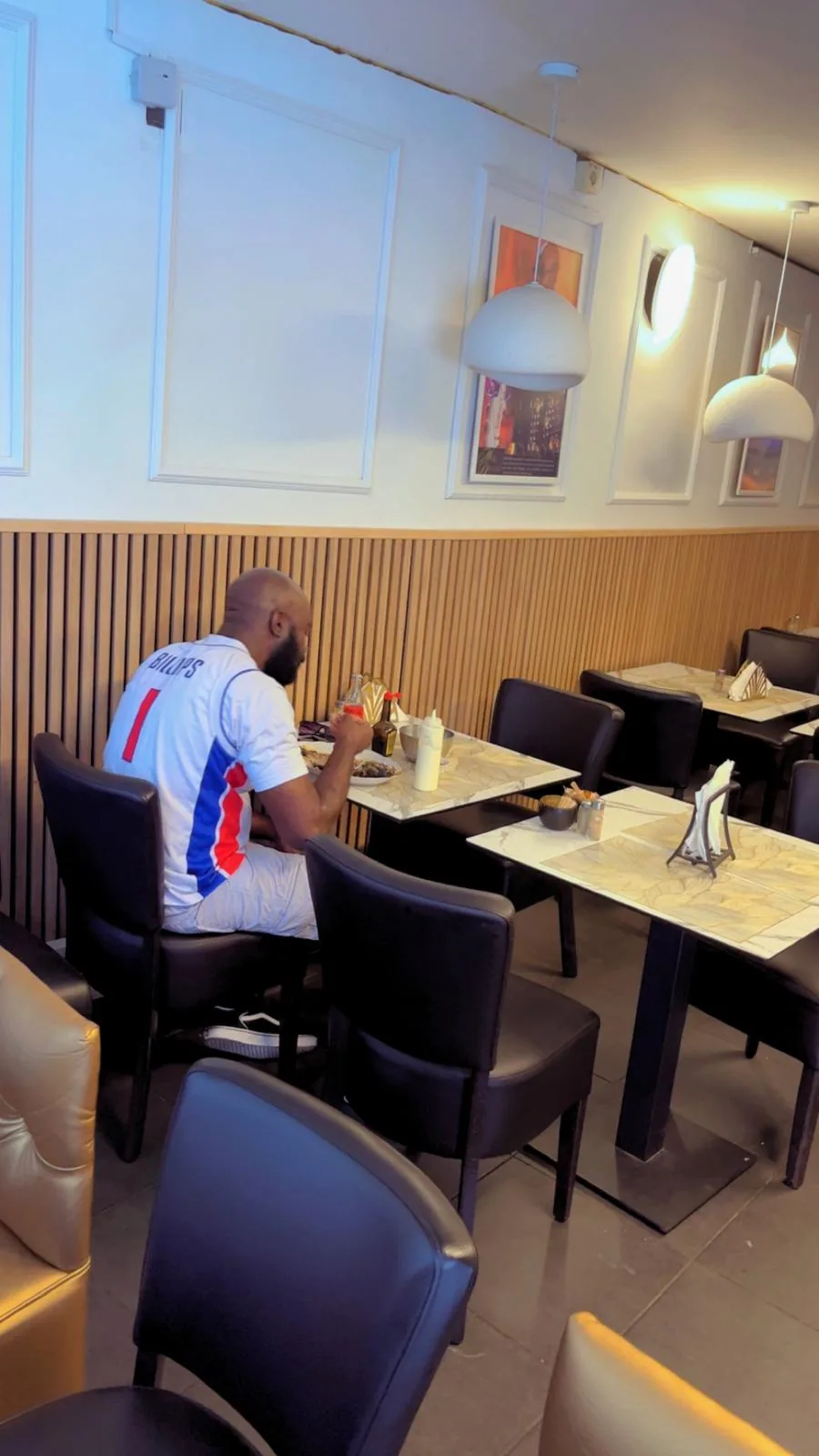 Client attablé dans la salle, banquettes et tables en marbre