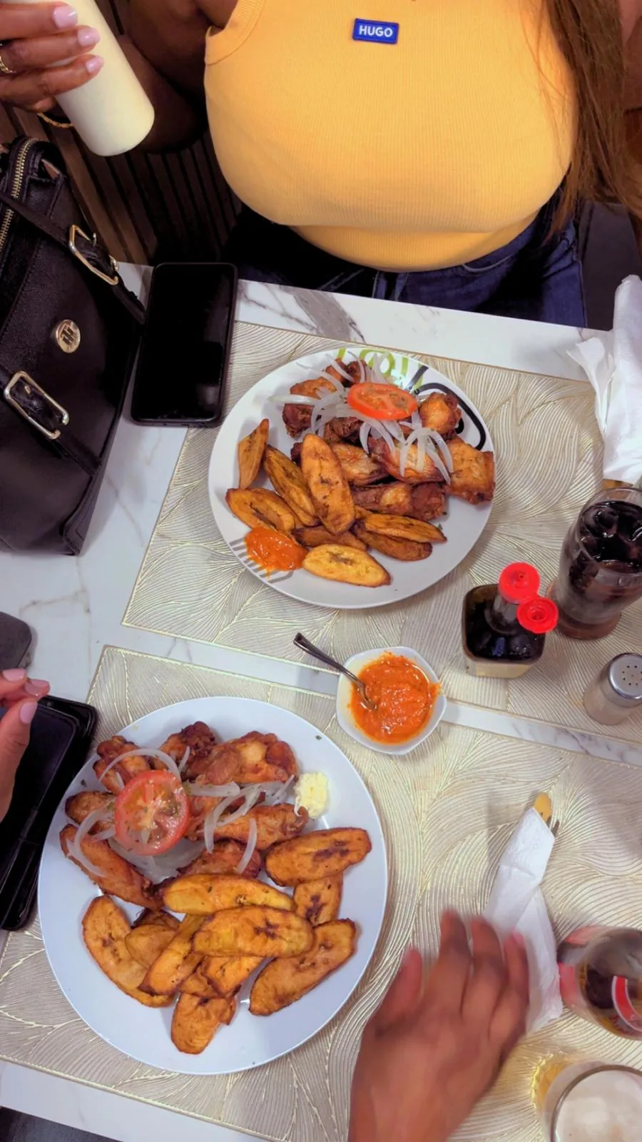 Deux assiettes d’ailes de poulet et bananes plantain frites, sauce pimentée